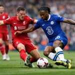 Two football players from Liverpool and Chelsea competing for the ball on the field.